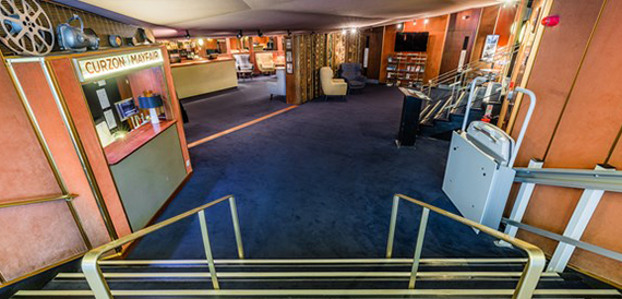 Art deco corridor with a Curzon Mayfair box office booth and steps