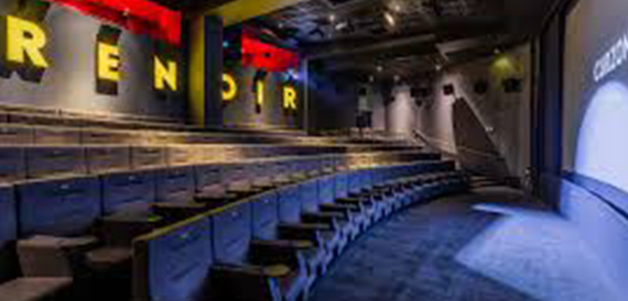 Screening room named Renoir with yellow lettering and blue tip-up seats