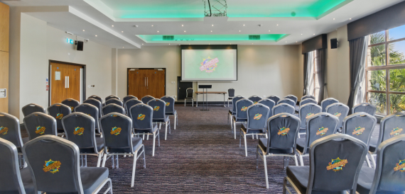 Conference room set theatre-style with branded chair covers and a screen