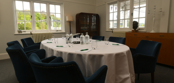 Round table set formally with navy blue upholstered chairs