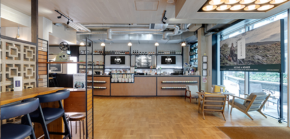 Bar area with shelves of bottles, a wooden counter and stools
