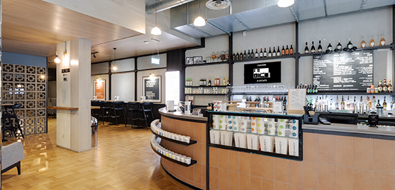 Curved bar counter with a drinks display and high stools