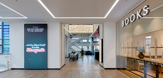Corridor with a digital film poster leading to a bookshop