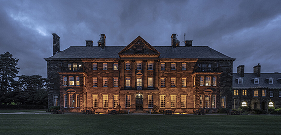 Crathorne Hall's stone exterior illuminated at dusk