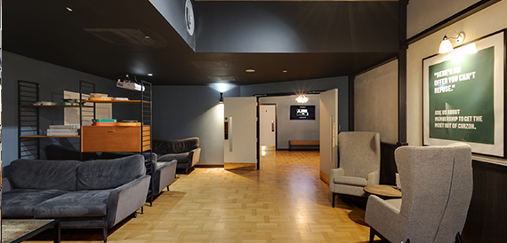 Lounge area with grey armchairs, sofas and wooden flooring
