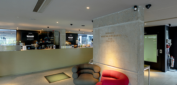 Bar area with a concrete pillar, red armchair and low lighting