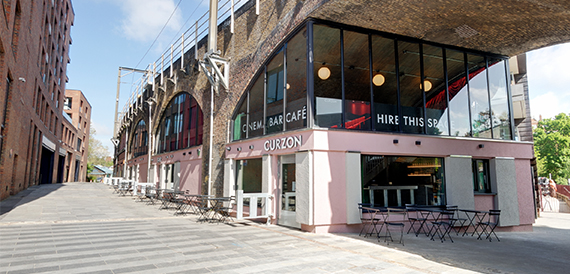 Curzon's arched brick exterior with cafe signage and outdoor seating