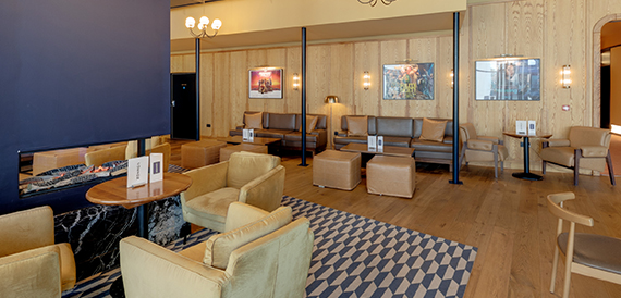 Lounge with a fireplace, mustard armchairs and framed artwork