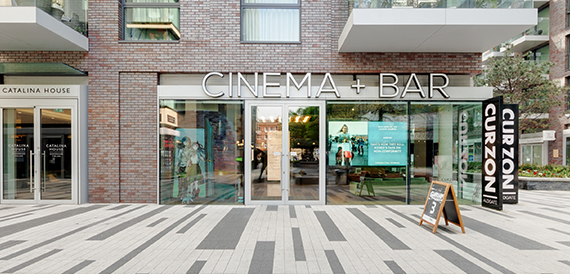 Cinema and bar shopfront exterior with glass doors and signage