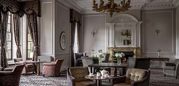 Lounge with armchairs and a tea set on a coffee table beside the fireplace