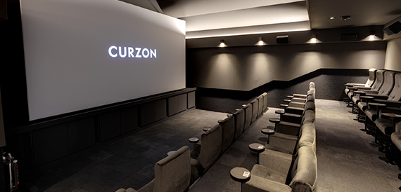 Grey screening room with velvet seats and round side tables