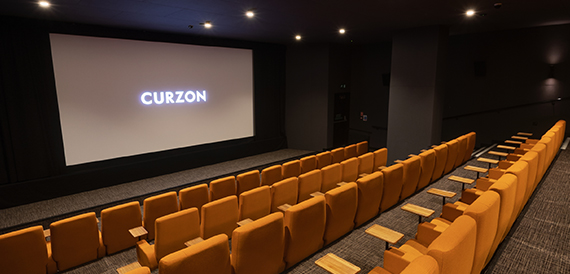 Cinema screening room with orange velvet seats facing the Curzon screen