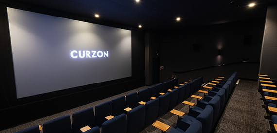 Cinema auditorium with navy seats facing an illuminated screen