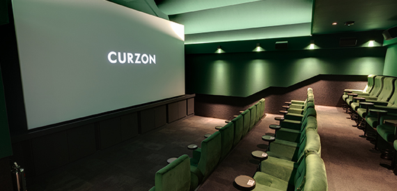 Green screening room with velvet seats and an illuminated Curzon screen
