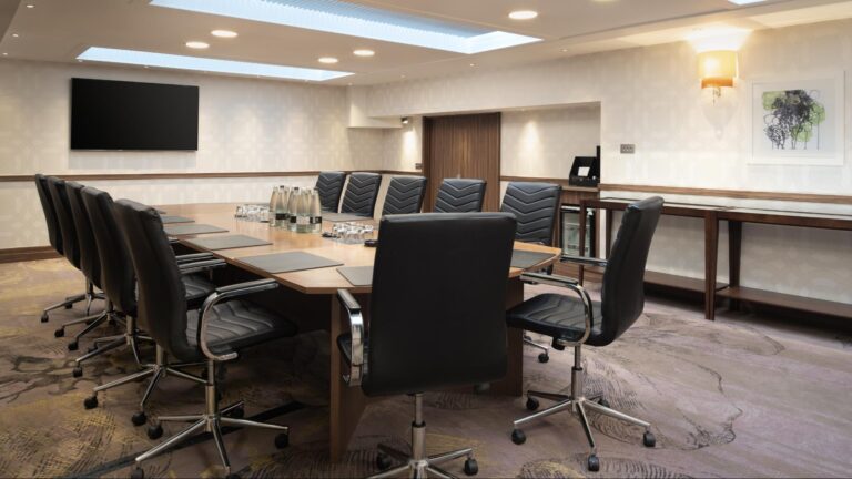 Boardroom with a long table, black leather chairs and a skylight