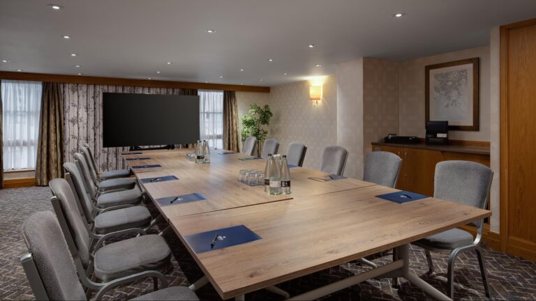 Holland Suite boardroom with a long wood table and grey chairs