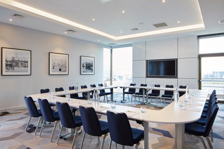 Meeting room set boardroom-style with a U-shaped table and framed artwork