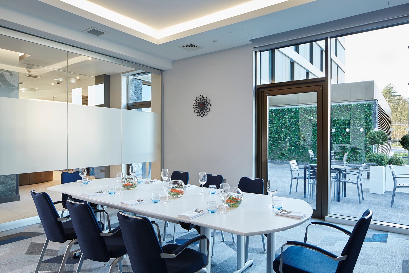 Meeting room boardroom table set with glass doors opening to a terrace