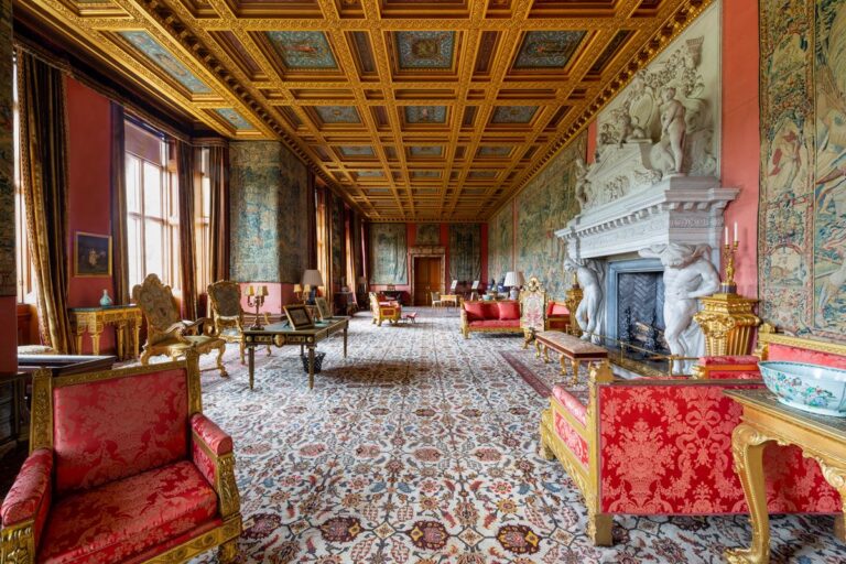 Long Gallery with a gilded ceiling, red furnishings and an ornate fireplace