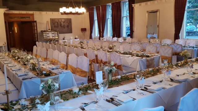Balavil Hotel dining room laid with gold-sashed chairs for a wedding breakfast