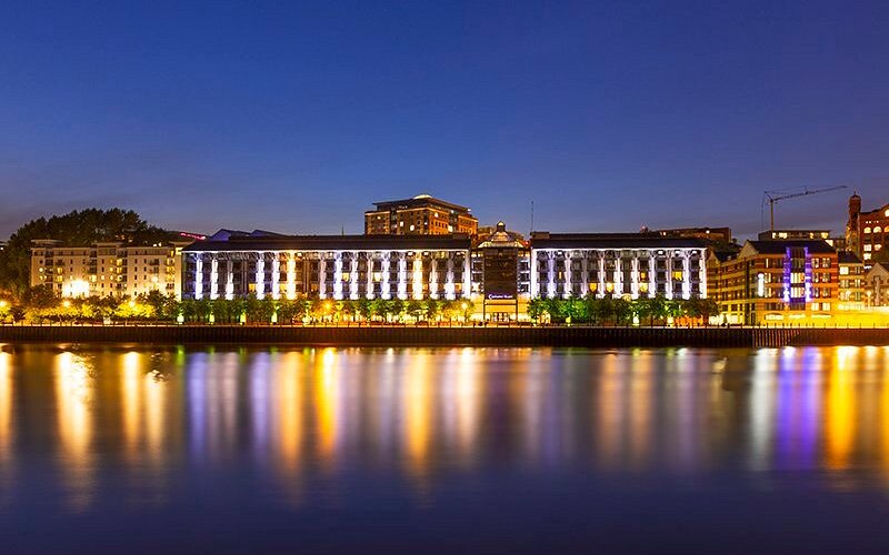 Waterfront building illuminated at night and reflected in the river