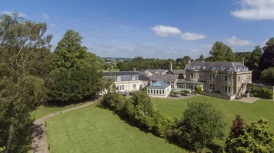 Aerial view of the manor house along a tree-lined driveway