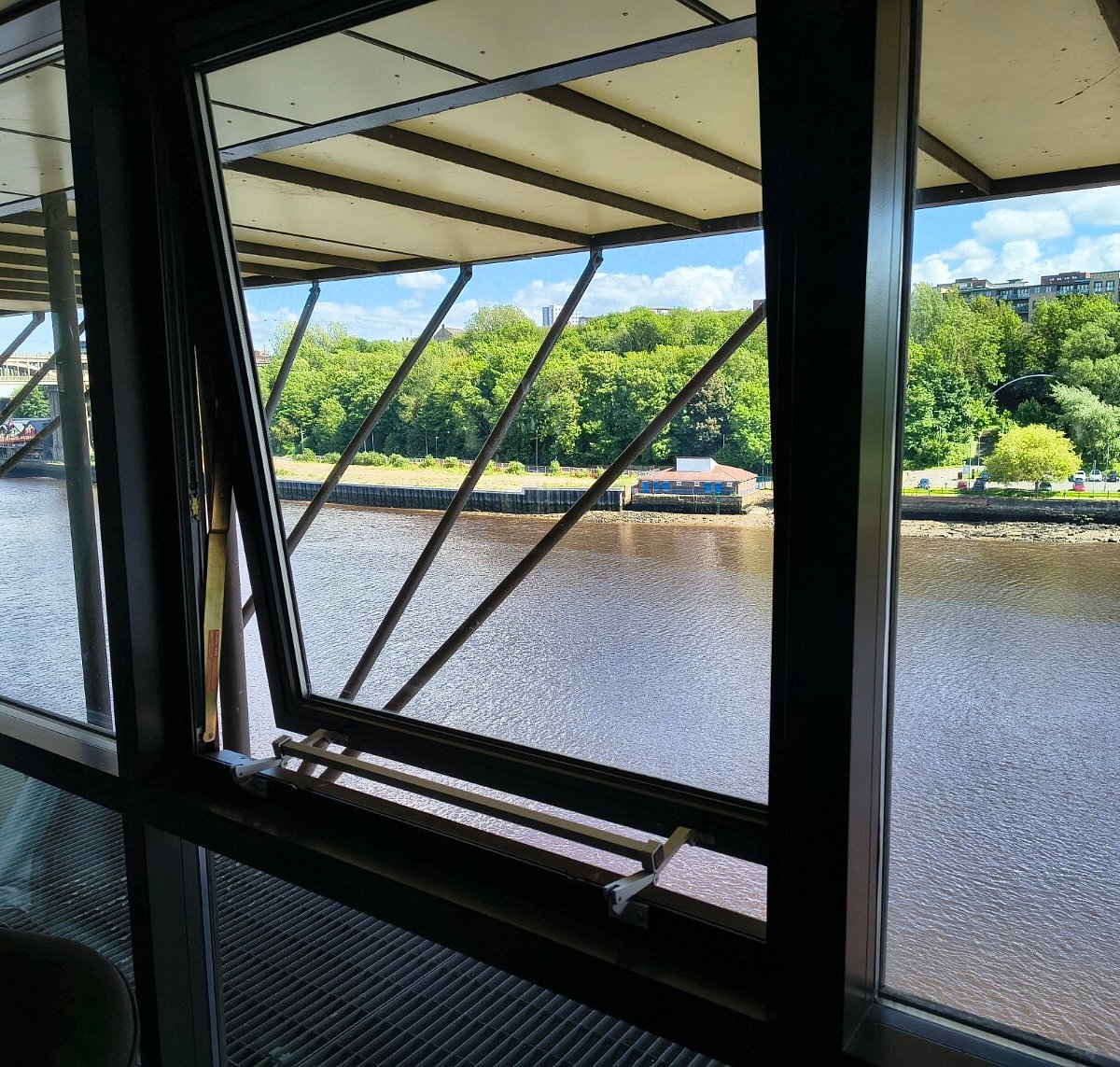 View through a hotel window overlooking the river and trees